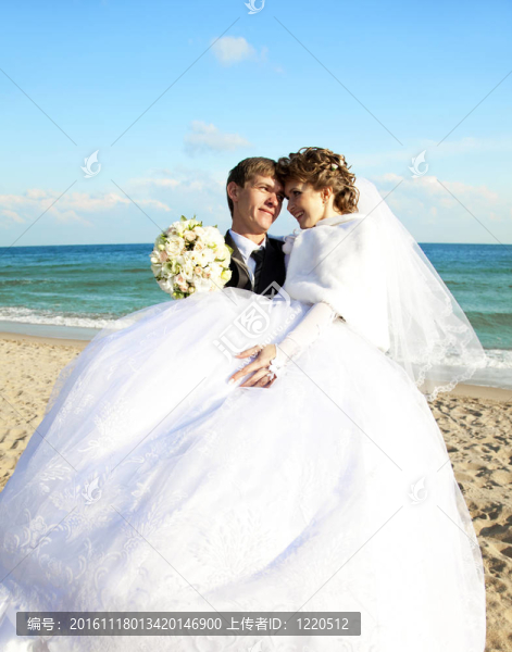 新婚夫婦在海灘上接吻。