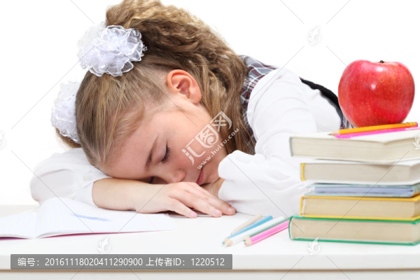 累了的小女孩睡在書上