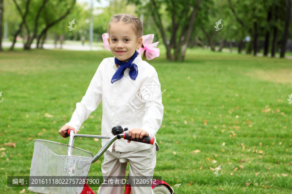 在綠色公園里騎自行車的女孩