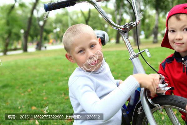 在綠色公園里騎自行車的男孩