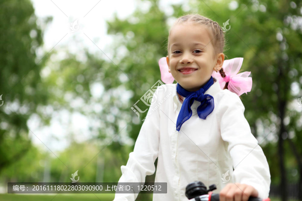 在綠色公園里騎自行車的女孩