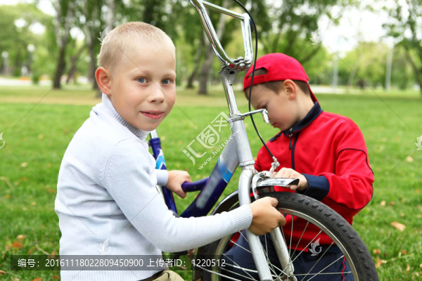 在綠色公園里騎自行車(chē)的男孩