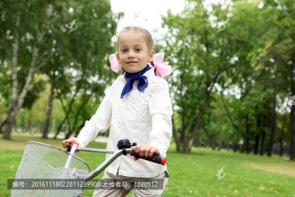 在綠色公園里騎自行車的女孩