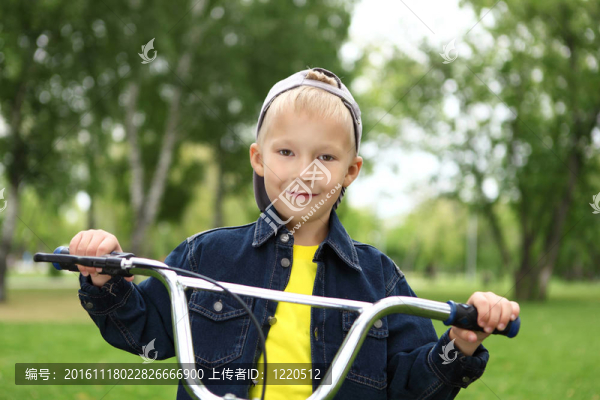在綠色公園里騎自行車的男孩