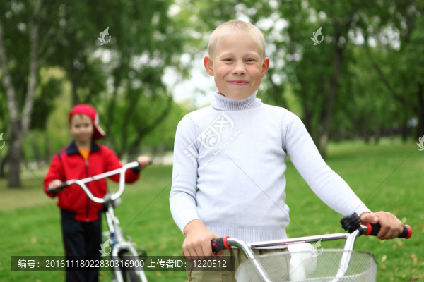 在綠色公園里騎自行車的男孩