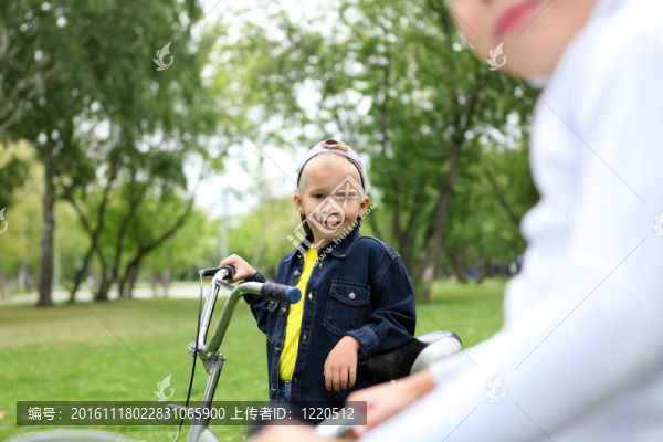 在綠色公園里騎自行車的男孩
