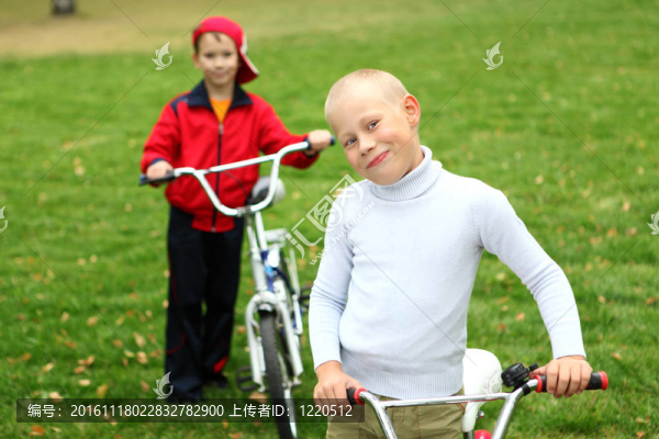 在綠色公園里騎自行車的男孩