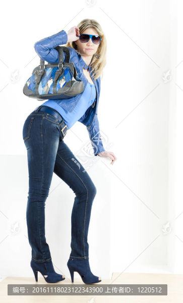 站著的女人穿著藍色的衣服和手提包