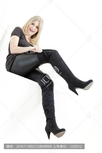 坐著的女人穿著時髦的黑靴子
