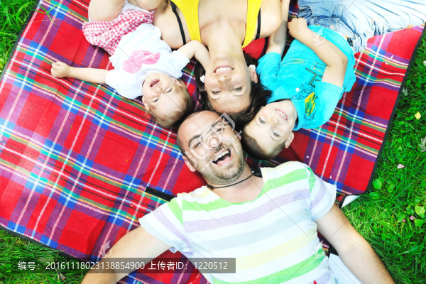 快樂的年輕夫婦和他們的孩子在公園玩得開心