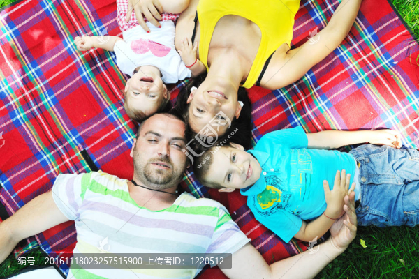 快樂的年輕夫婦和他們的孩子在公園玩得開心