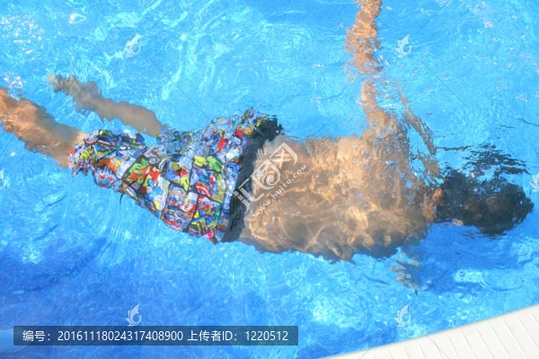 男孩在游泳池里游泳