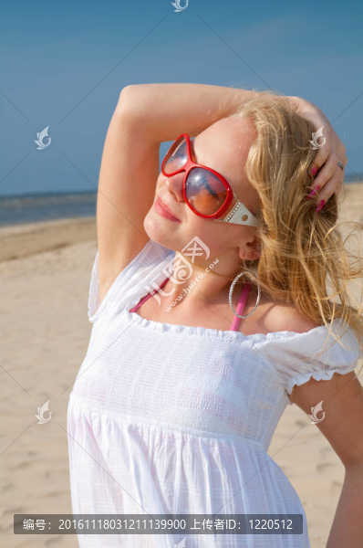 穿夏天衣服的女人站在沙灘上