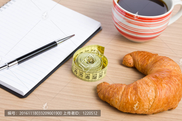 飲食的概念。牛角包和卷尺