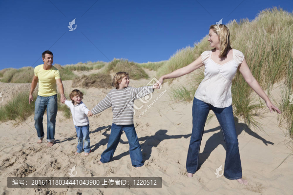 父親和兩個男孩在Beach手拉手