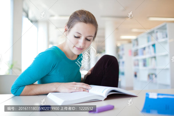 年輕漂亮的大學(xué)生在圖書館（淺景深；顏色色調(diào)的圖像）