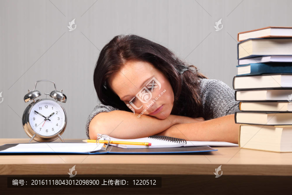 深夜作業(yè)婦女在課桌上睡著了