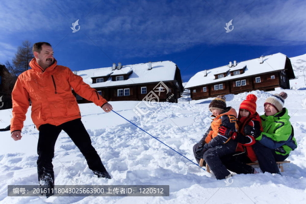 父親拉著孩子在雪橇上