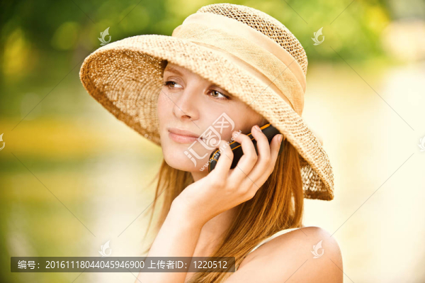 戴電話的戴著帽子的女孩