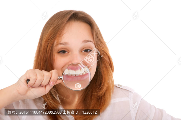 通過放大鏡的年輕女人的牙齒