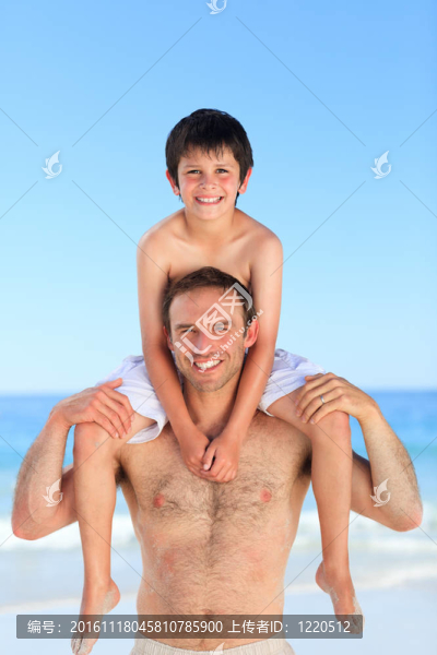 在海灘上的兒子背著父親