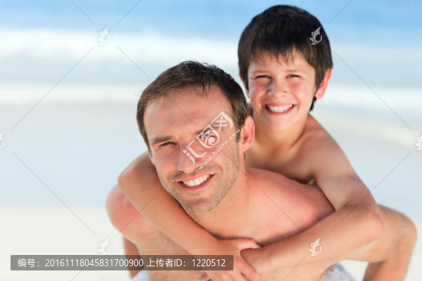 在海灘上的兒子背著父親