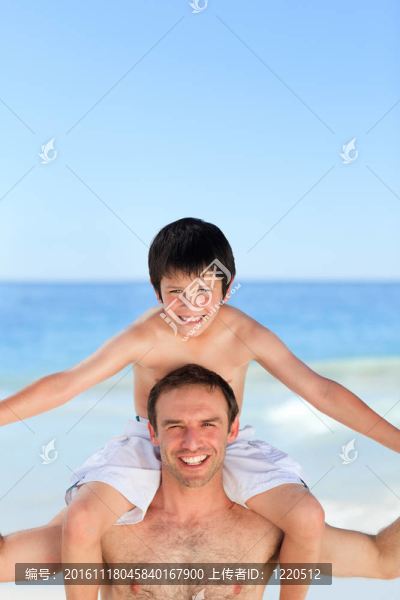 在海灘上的兒子背著父親