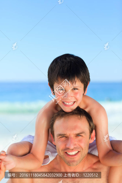 在海灘上的兒子背著父親