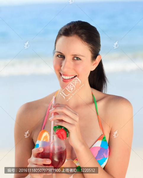 美麗的女人在海灘上喝雞尾酒