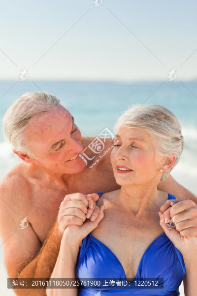 男子在海灘上擁抱他的妻子