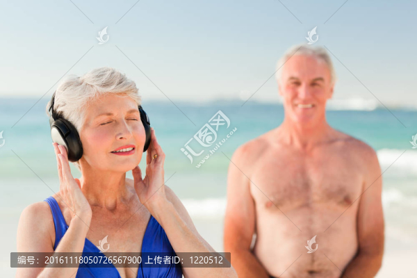 在海灘上聽音樂的女人
