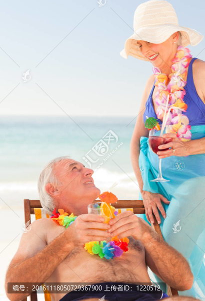 夫婦在海灘上喝雞尾酒