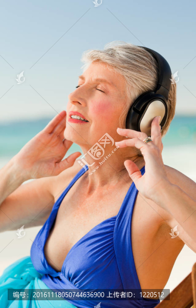 高級女子在海灘聽音樂