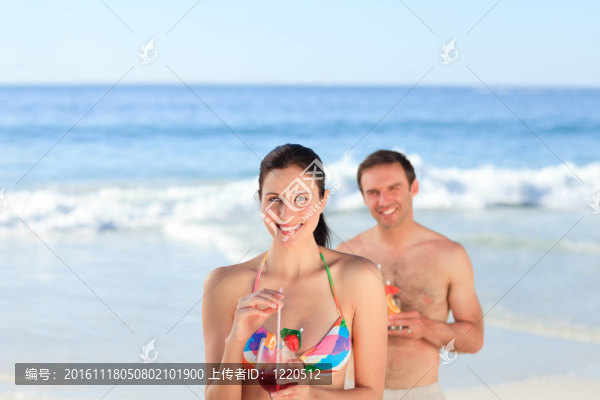 夫婦在海灘上喝雞尾酒
