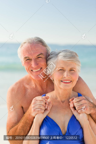 男子在海灘上擁抱他的妻子