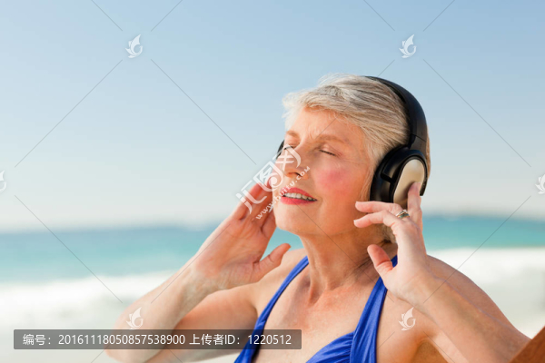 高級女子在海灘聽音樂