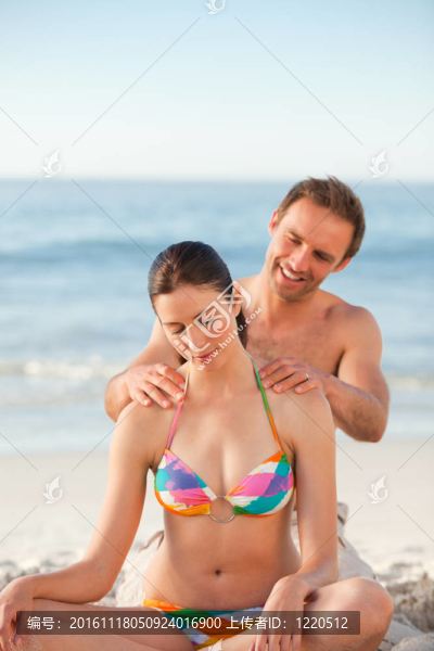 細心的男人在女朋友的背上涂防曬霜