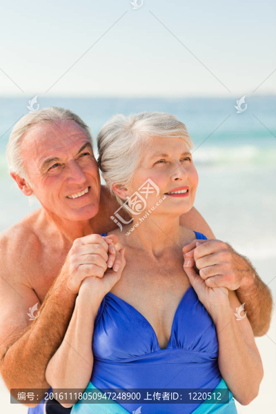 男子在海灘上擁抱他的妻子