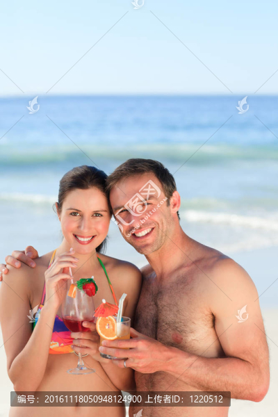 夫婦在海灘上喝雞尾酒
