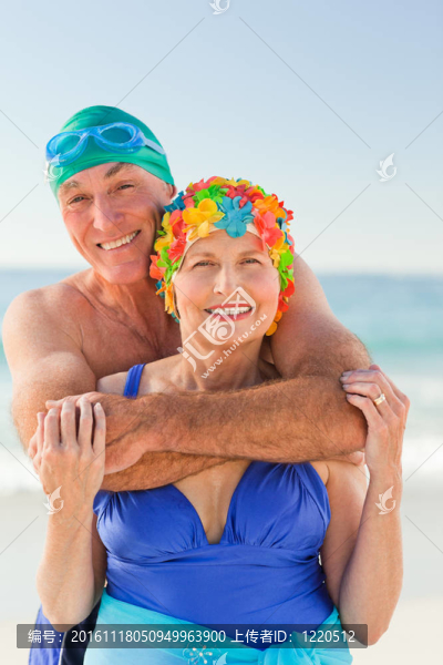 男子在海灘上擁抱他的妻子