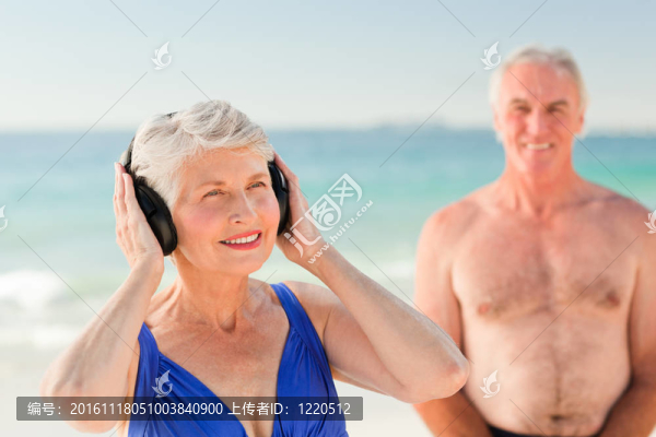 在海灘上聽音樂的女人