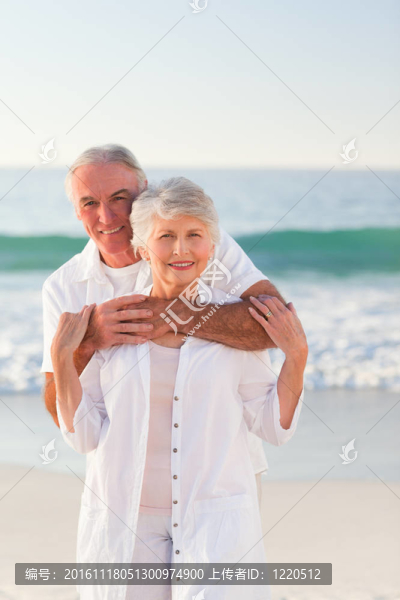 男人抱著他的妻子在海灘上