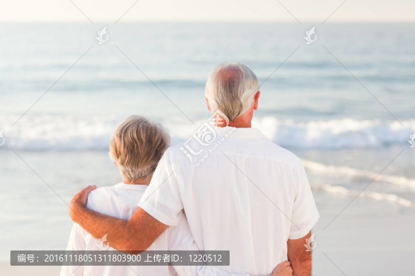 男人抱著他的妻子在海灘上