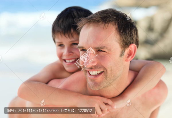 在海灘上的兒子背著父親