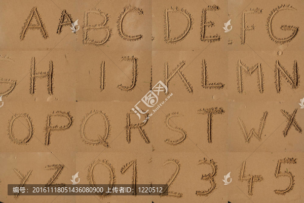 沙灘上用沙子寫的字母表。