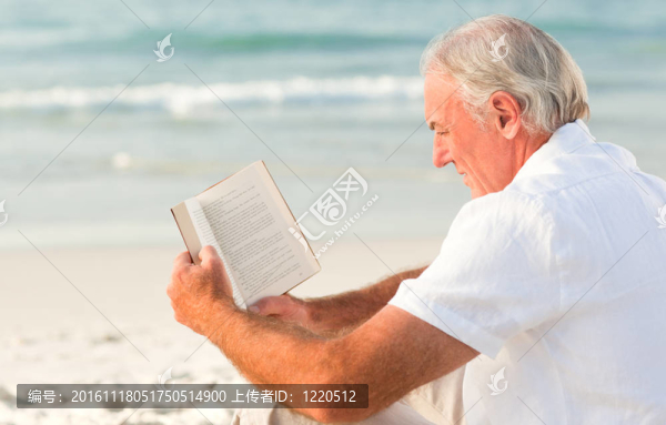 男子在海灘上讀一本書