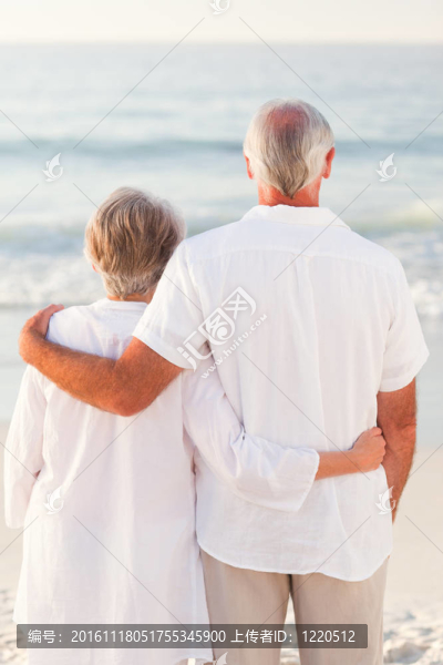 男人抱著他的妻子在海灘上