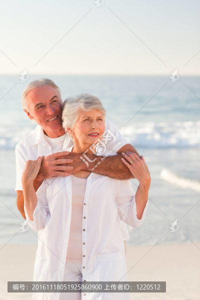 男人抱著他的妻子在海灘上