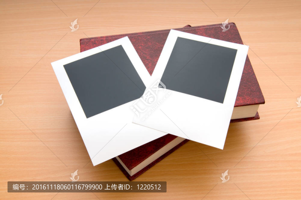 木制桌子上的書和空白照片