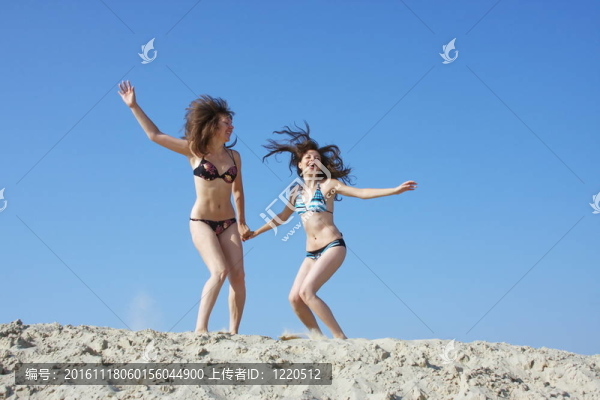 兩個美麗的女孩在一個沙坑
